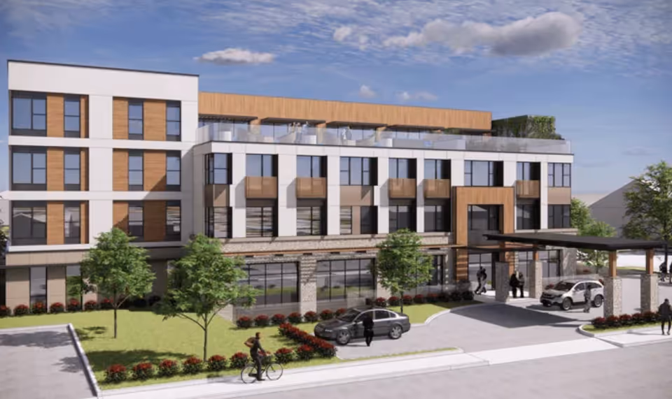 Exterior view of a modern multi-story assisted living facility with large windows, balconies, and a covered entrance. There are trees, shrubs, and a few people walking and standing near the entrance and on the sidewalk. Two cars are parked near the entrance under a canopy.