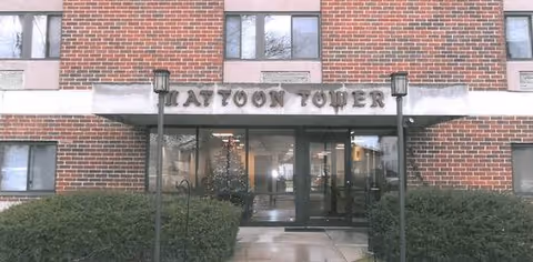 Entrance to Mattoon Tower senior living facility with brick exterior and glass doors