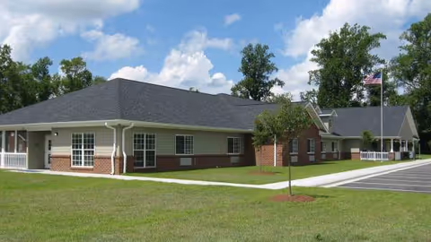 Single-story senior living facility with brick and siding exterior and a parking lot.