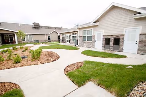 Outdoor view of Kennybrook Village building exterior with curved sidewalks and green landscaping.
