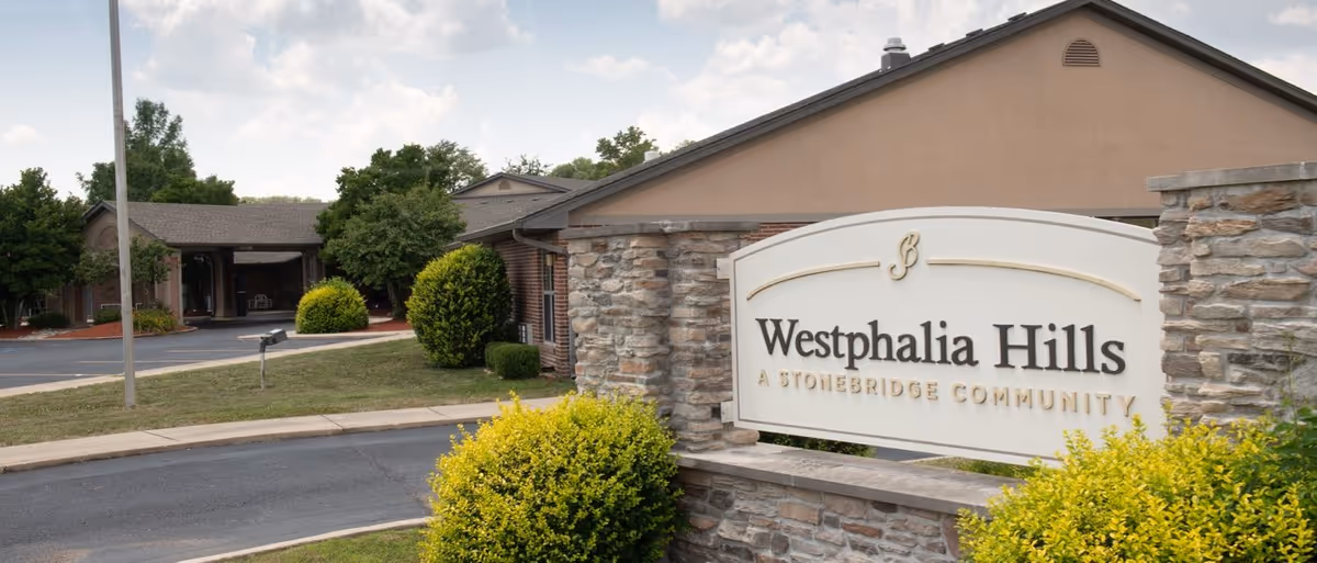 Entrance sign for Westphalia Hills, a Stonebridge community, in front of the facility building and landscaping.
