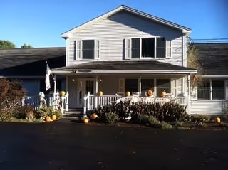 Two-story retirement home with pumpkins decorating the front porch.