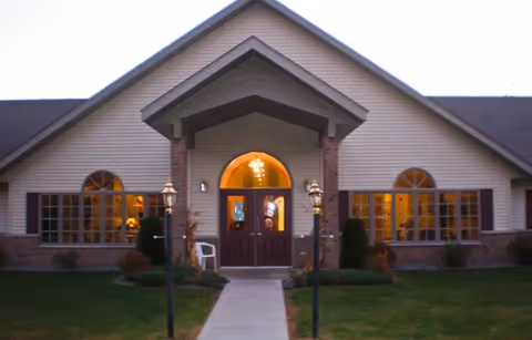 Front view of a senior living facility with arched windows and central doors