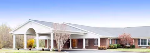 A single-story brick senior living facility with a covered entrance and arched portico