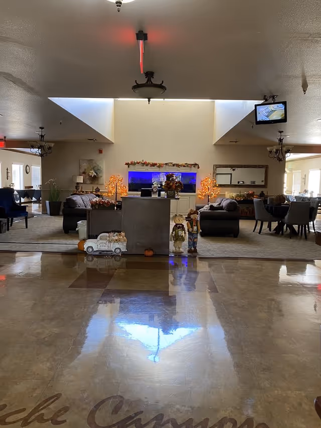 A spacious senior living lobby with holiday decor, seating areas, and a central reception desk.