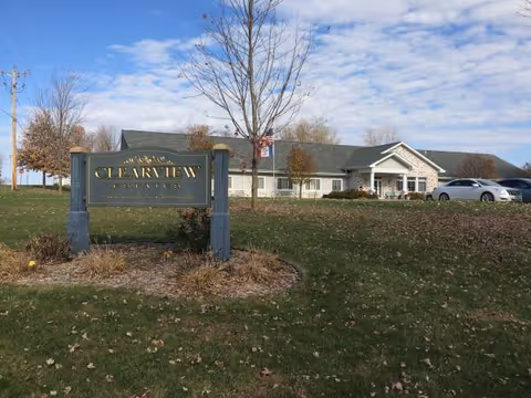 Front exterior of Clearview Estates Assisted Living with sign and parked cars