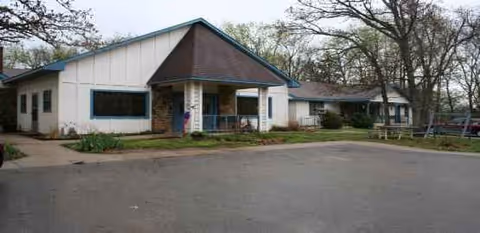 Exterior view of Guest Home Estate III facility with entrance and parking.