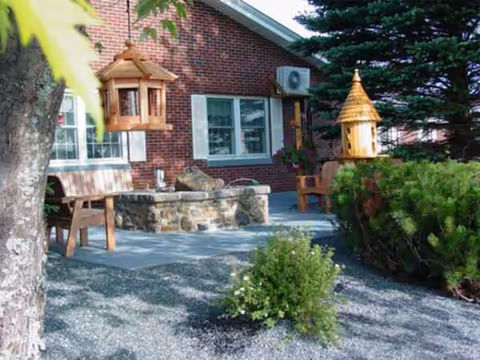 Outdoor patio area with benches, birdhouses, planters, and a brick building facade.