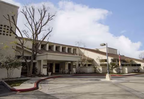 Exterior view of Sunrise at Sterling Canyon facility with entrance, parking, and landscaping.