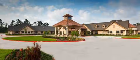 Exterior view of Villa Toscana at Cypress Woods with entrance, parking, and manicured landscaping.