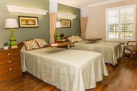 Twin beds with matching comforters in a shared resident bedroom.