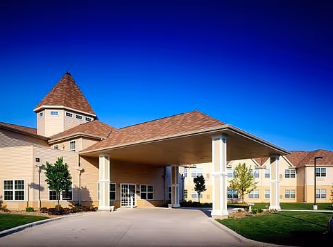 Exterior view of Evergreen Place Assisted Living front entrance with a covered driveway and turret.