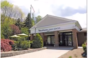 Front entrance of Woodhaven Care Center with brick exterior and landscaping.