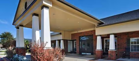 Front exterior view of Bedford Estates Senior Living with brick facade and covered entrance.