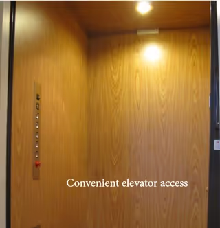 Interior of an elevator with wood-paneled walls and a control panel with buttons on the left side. A light is on at the top, and text on the wall reads 'Convenient elevator access'.