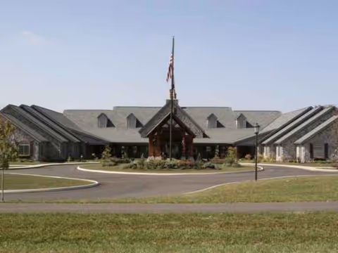 Exterior view of a senior living facility with a circular driveway and front entrance.