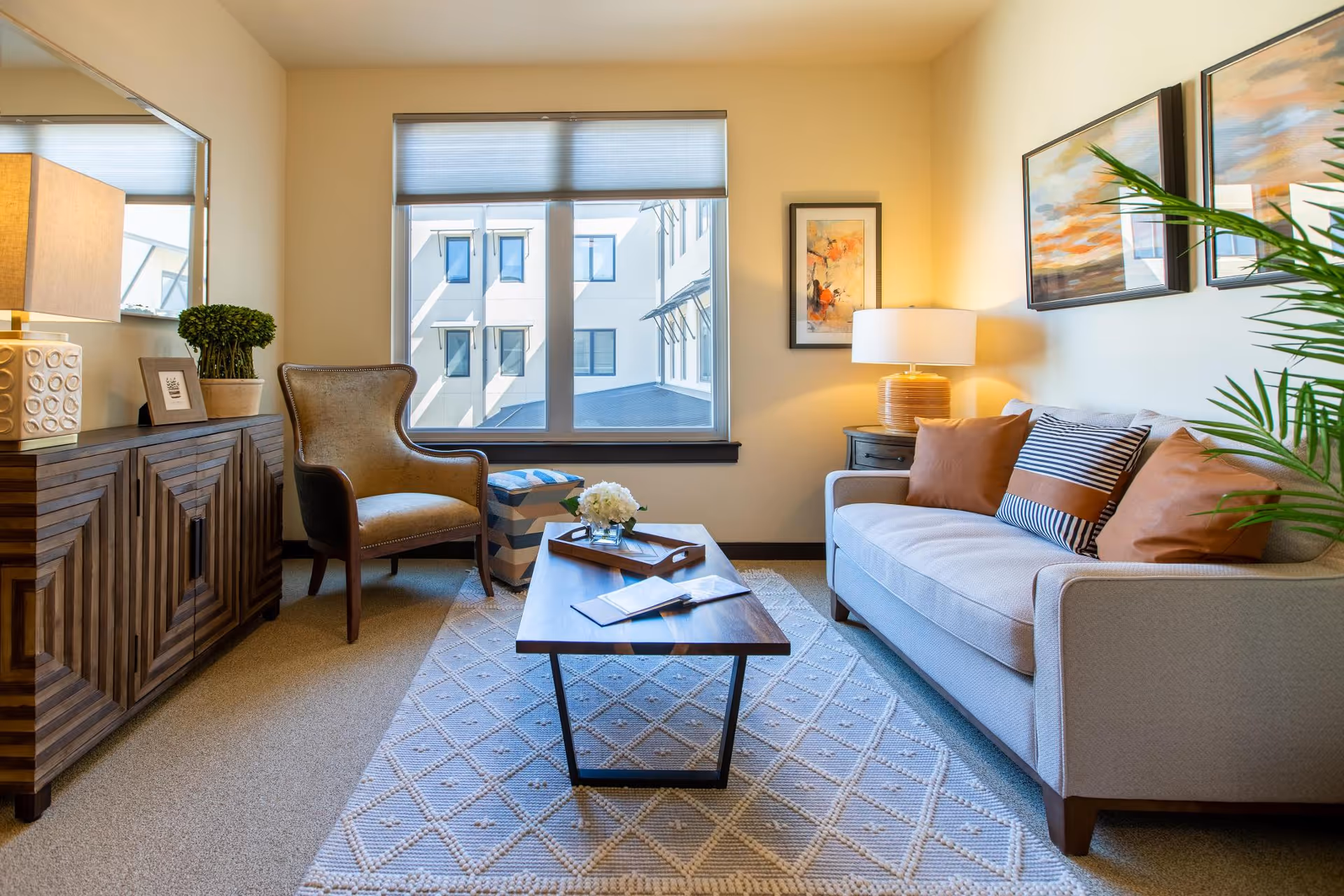 Bright furnished living room with a sofa, armchair, coffee table and window.