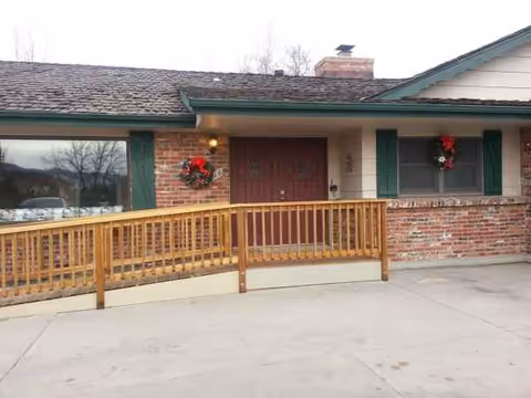 Front entrance of Meadow Vista Assisted Living at Wadsworth, brick exterior with wreaths and railing.