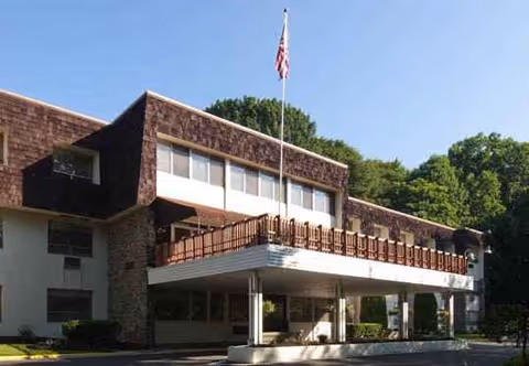 Elkins Crest Health and Rehabilitation Center exterior with flag and covered entrance.
