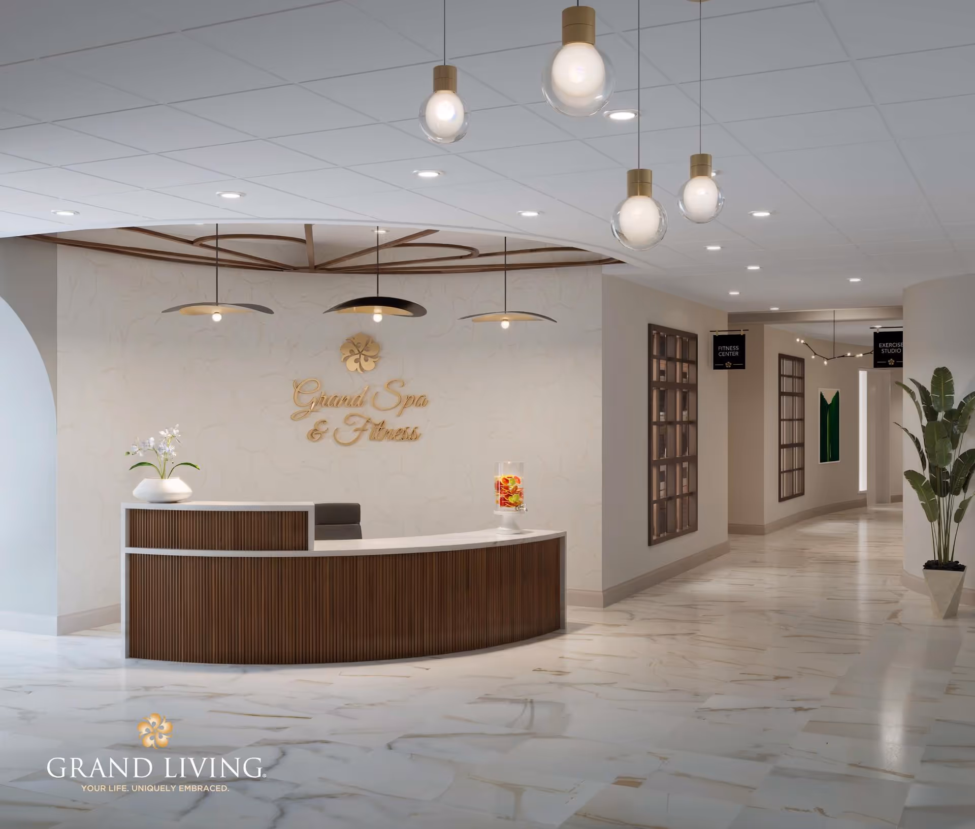 Reception area of Grand Spa & Fitness with a curved wooden desk, a white vase with flowers, and a glass container with fruit water. The floor is marble, and the ceiling has modern hanging lights. Signs indicate directions to the Fitness Center and Exercise Studio down a hallway.