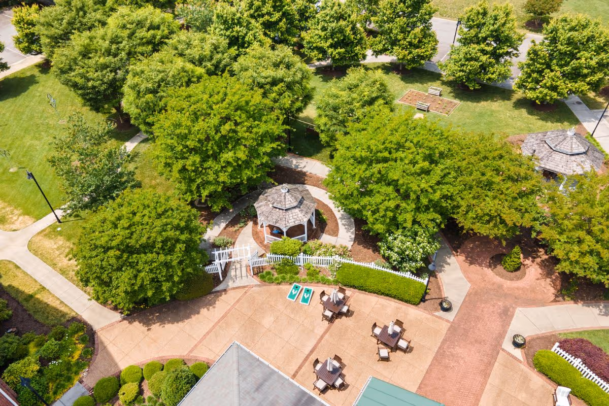 Aerial view of a landscaped outdoor courtyard with gazebos, trees, walking paths, and patio seating.