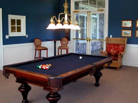 A billiards table dominates a lounge area with blue walls and seating.