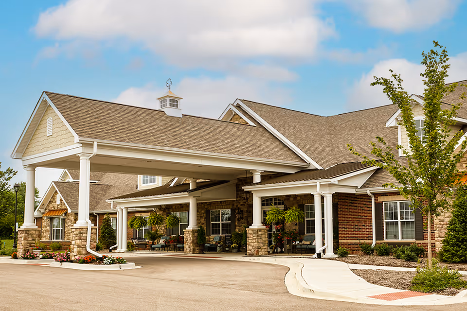 Front view of Bickford of Aurora entrance with covered driveway and stone columns.