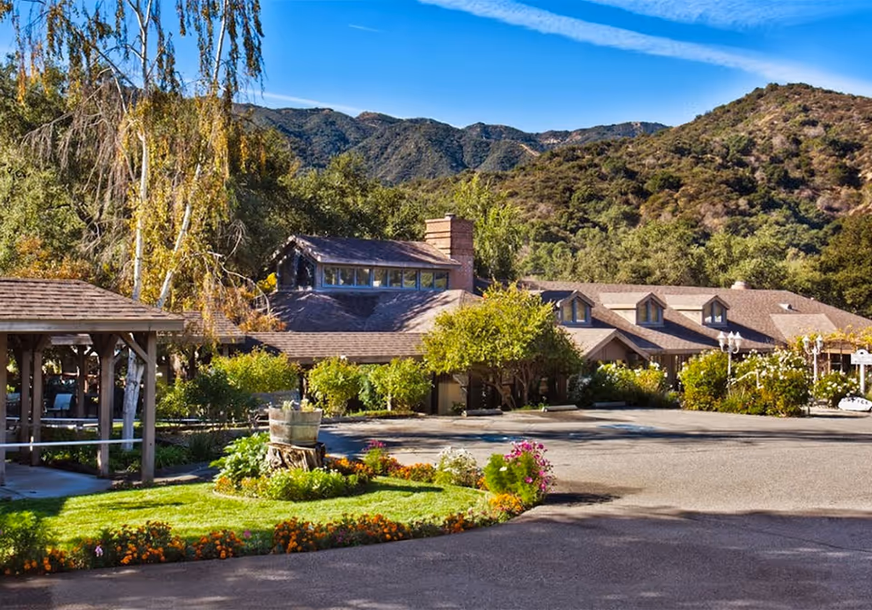 Exterior view of Twelve Oaks facility with landscaped front and hills.
