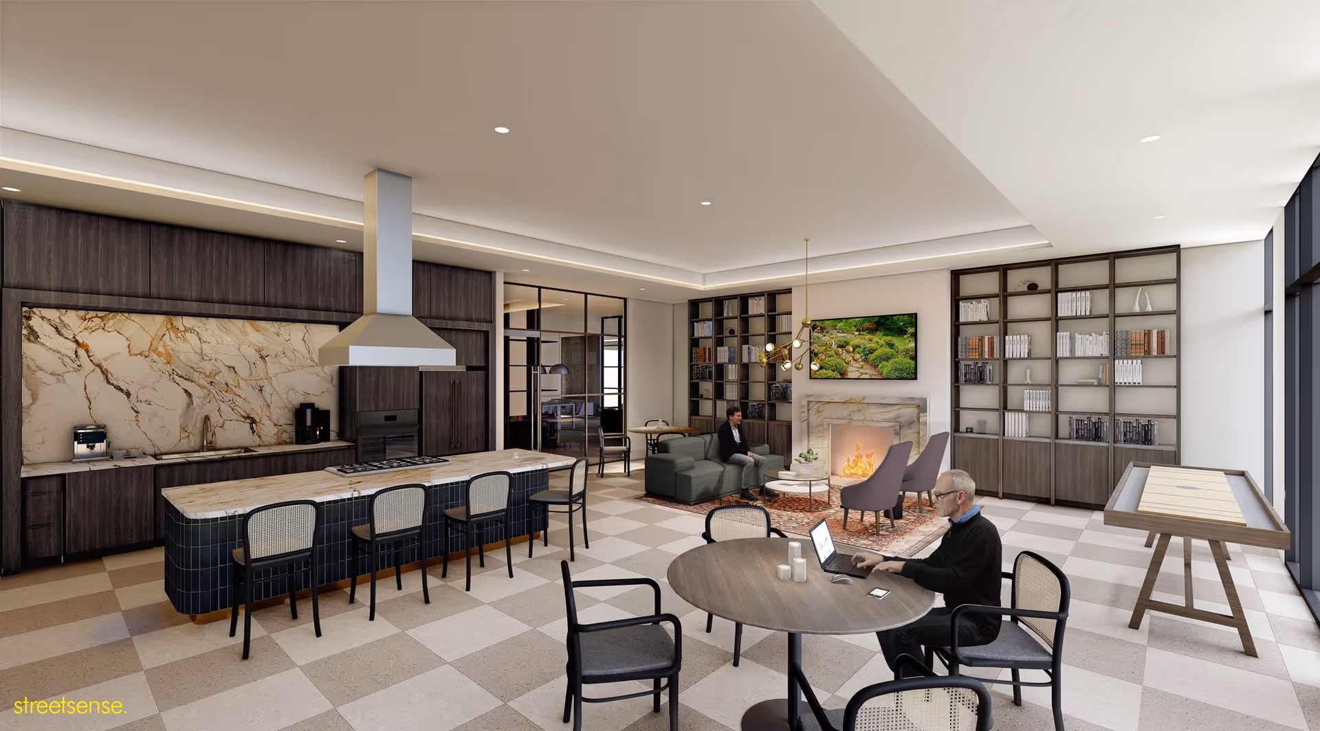 A modern senior living common area featuring a kitchen with dark wood cabinets, a marble backsplash, and a large island with seating. The room also includes a seating area with a fireplace, a wall-mounted TV, bookshelves, and a shuffleboard table. Two men are present, one sitting on a couch near the fireplace and another working on a laptop at a round table.