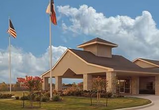 Exterior view of Eagle Crest Rapid Recovery entrance with flags and landscaped grounds.