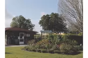 Exterior view of Good Samaritan Society Kissimmee Village with garden and entrance near trees.