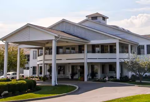 Ashwood Place exterior: covered entrance, circular driveway, and well-kept landscaping.