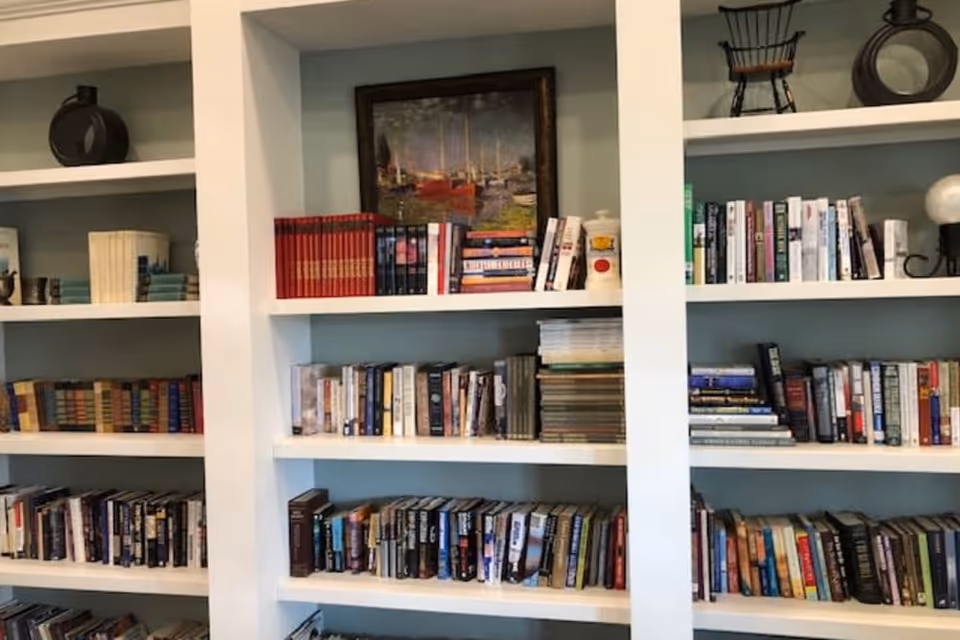 Built-in white bookshelves filled with books and decorative items.