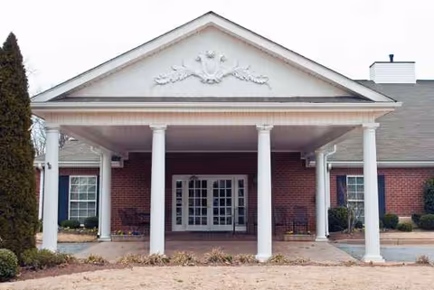 Windsor House Greenville entrance with white columns and brick exterior.