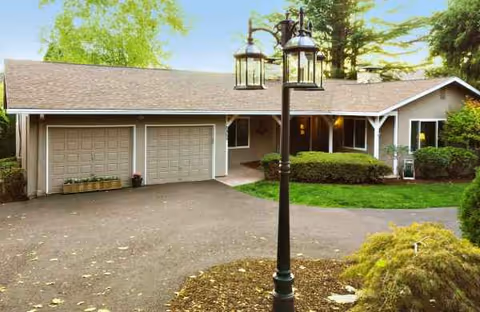 Front view of a single-story senior living facility with a two-car garage and lamp post.