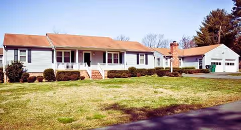 Front exterior of The Haven Assisted Living at Eleanor, single-story building with porch and lawn.