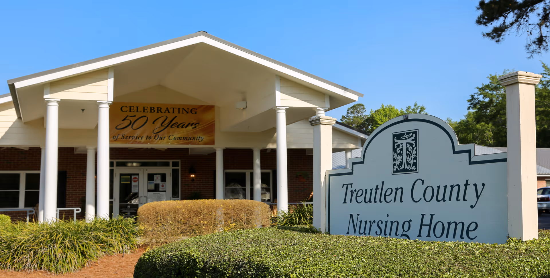 Front entrance of Treutlen County Nursing Home with a large outdoor sign and a banner celebrating 50 years.