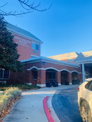 Brick senior living facility entrance labeled Morningside House of Ellicott City with parked car