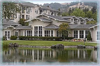 Multiple ranch-style senior living buildings surround a tranquil pond with landscaped lawn at Rossmoor Walnut Creek.