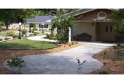 Exterior view of a senior living facility with a curved walkway and trees.
