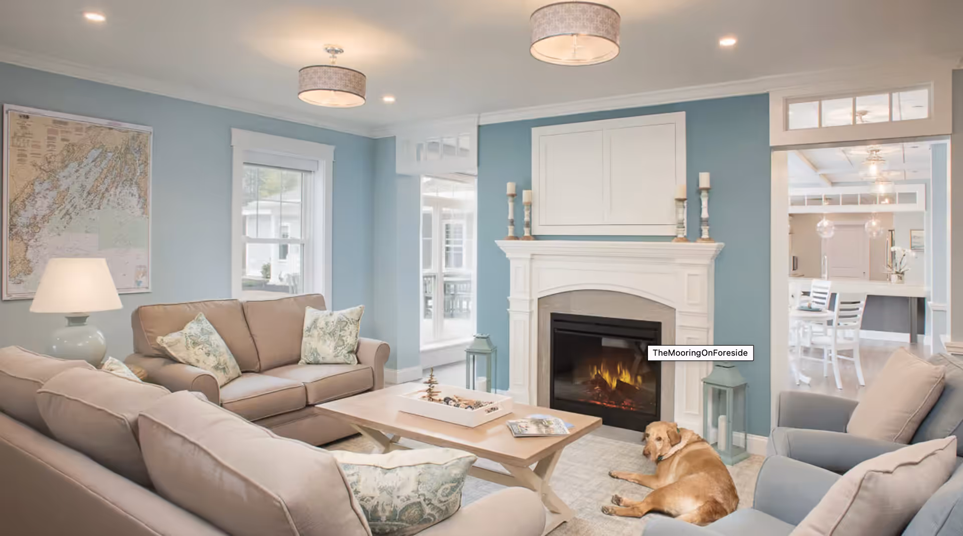 Bright living room with sofas, a coffee table, a fireplace, and a dog lying on the rug.