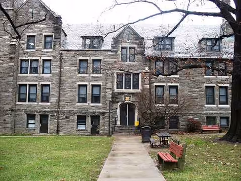 Exterior view of the Inglis House building with lawn and benches.