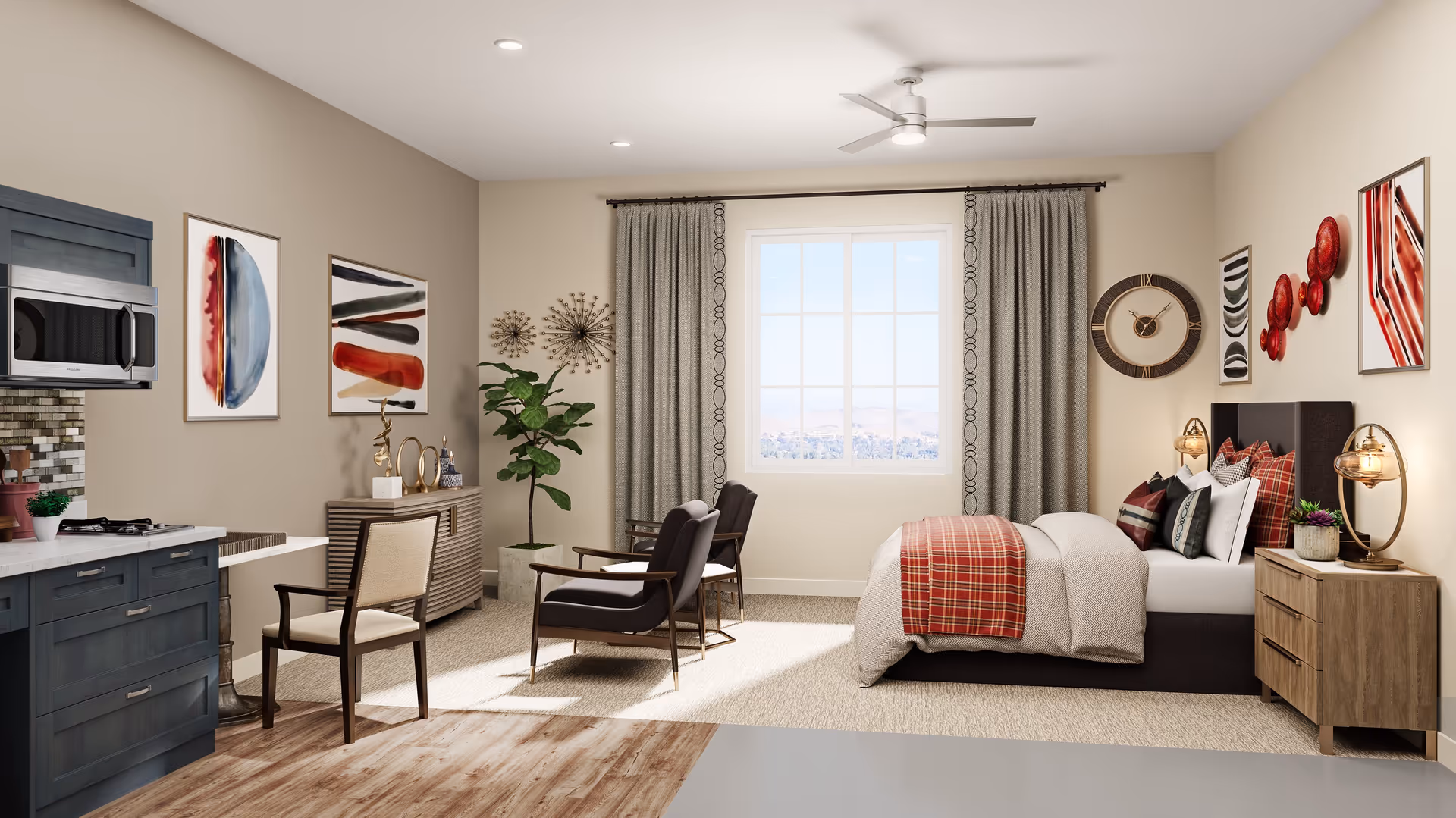 A cozy, well-lit bedroom with a large window covered by curtains, a bed with red and beige bedding, two armchairs facing the window, a wooden nightstand with a lamp and plant, a dresser with decorative items, and a small kitchenette area with a microwave and stove. The walls are decorated with modern art and a clock.