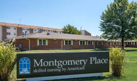 Exterior view of Montgomery Place senior living facility with a sign and lawn.