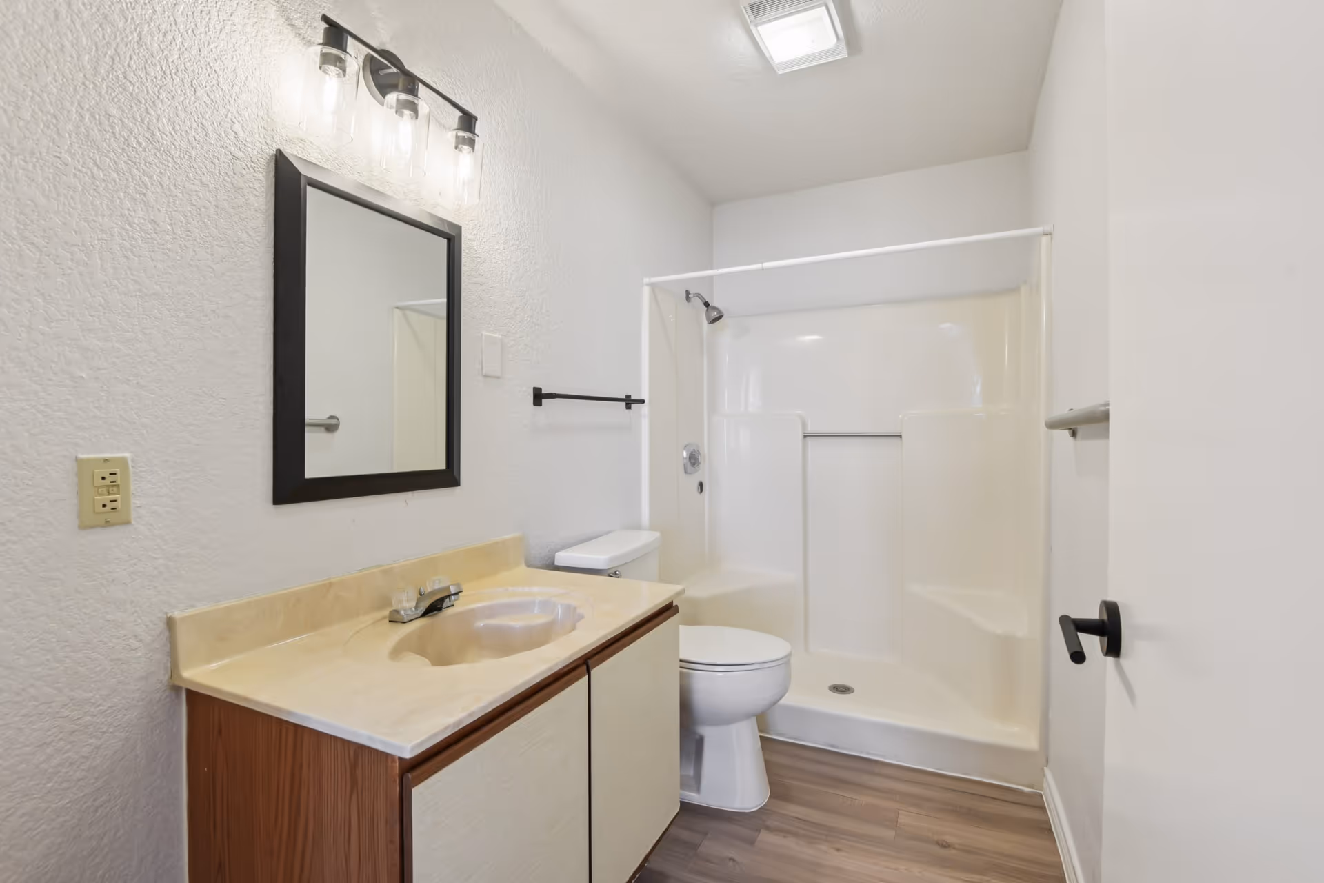 Bathroom with vanity, mirror, toilet, and shower in a clean, neutral space.