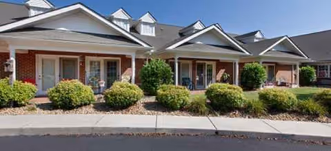 Exterior view of Brookdale Rock Springs senior living building with multiple entrances and manicured shrubs.