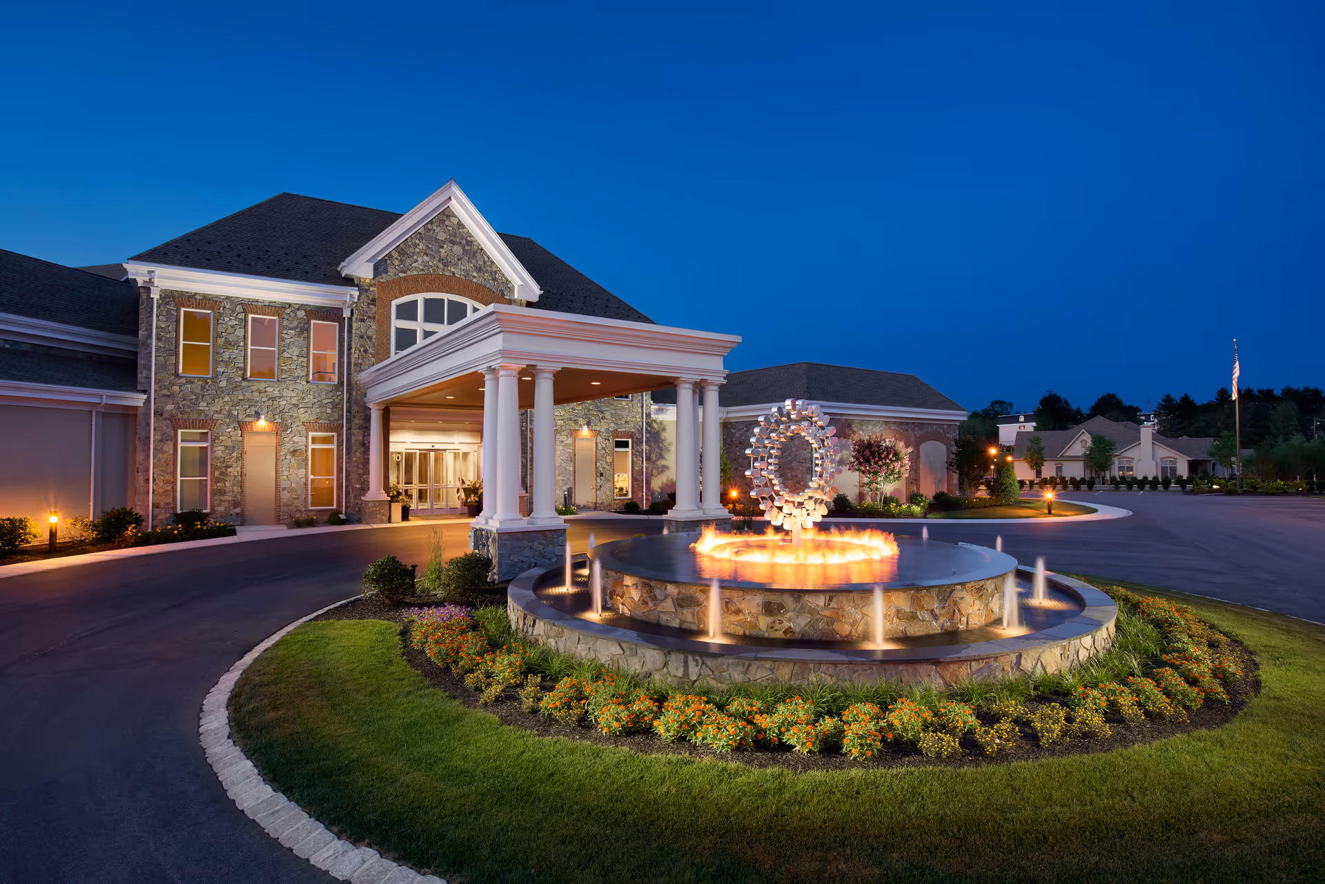 Exterior view of Lakes at Willow Valley Communities with a circular fountain at the entrance.