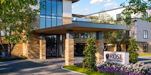 Exterior view of Rose Senior Living entrance with a covered drop-off and landscaping.