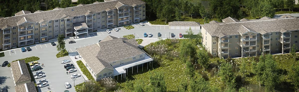 Aerial view of Glenmont Abbey Village showing multiple residential buildings surrounded by trees and greenery, with parking lots and cars visible between the buildings.