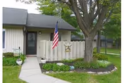 Exterior view of Homewood Living Williamsport entrance with flag, tree, and garden.